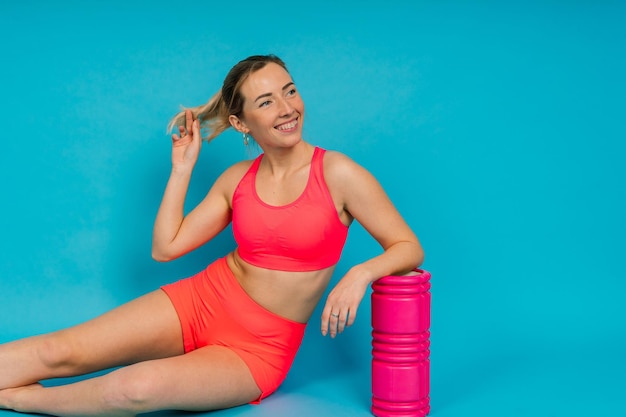 Beautiful female with dumbbells posing on studio background