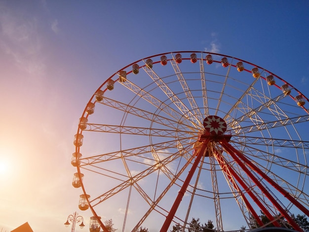 Beautiful Ferris Wheel with passenger-carrying cabins is in the park