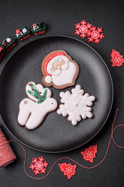 Beautiful festive Christmas gingerbread made by hand with decoration elements on a dark concrete background