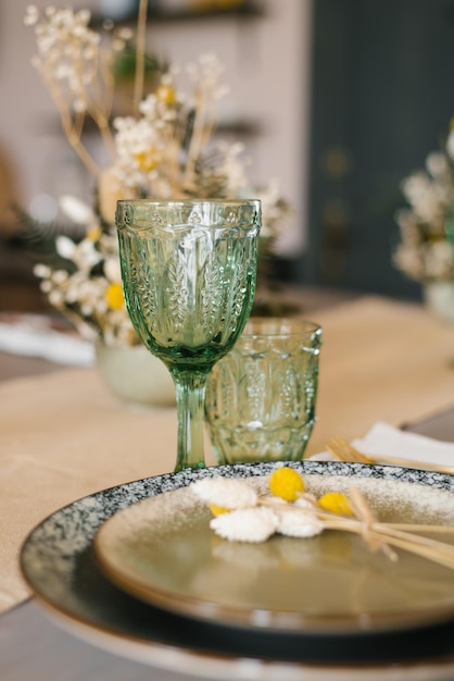 소박한 스타일의 아름다운 축제 식탁. 녹색 유리 텀블러와 유리
