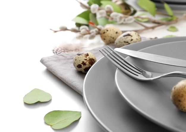 Beautiful festive Easter table setting with eggs on white background closeup