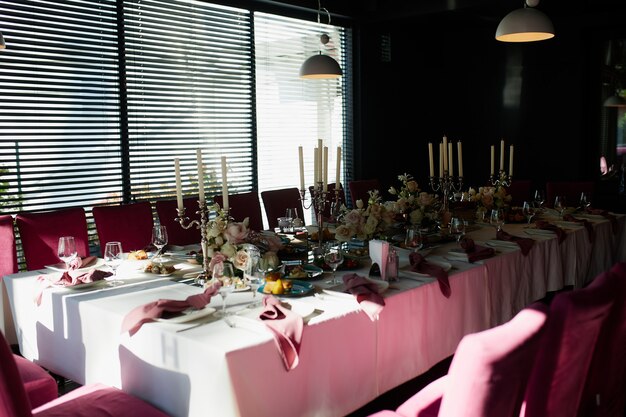 Photo beautiful festive table setting with candles and flowers.