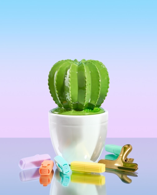 A beautiful figurine of a large green cactus on gradient background Office supplies