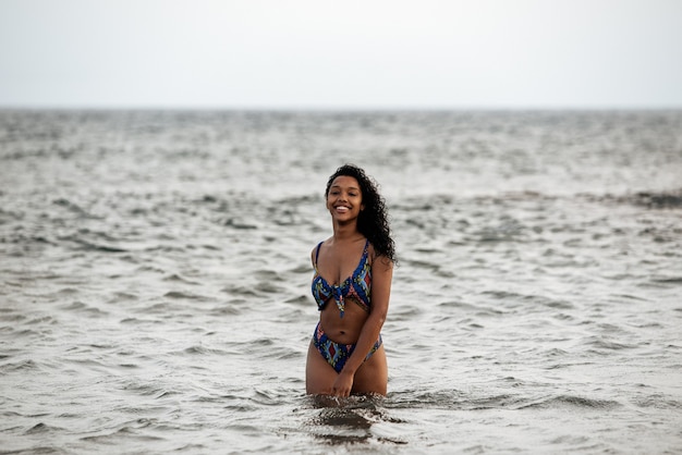 Bella vestibilità giocosa donna nera in bikini in una spiaggia vulcanica a santo antao, capo verde