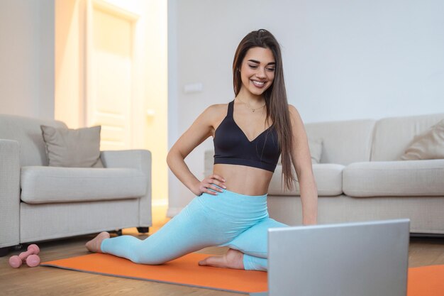 Beautiful Fitness female doing warmup workout at home Fitness woman doing stretch exercise stretching her legsquadriceps Fit girl living an active lifestyle