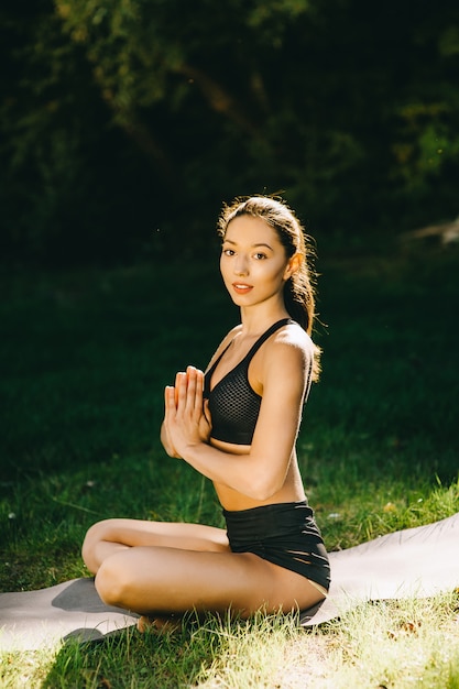 Beautiful fitness girl exercising in nature on sunny summer day