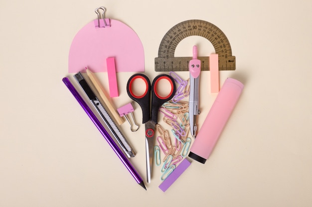 Beautiful flat layout of school supplies scissors pink marker ruler colored pencils paper clips beau...