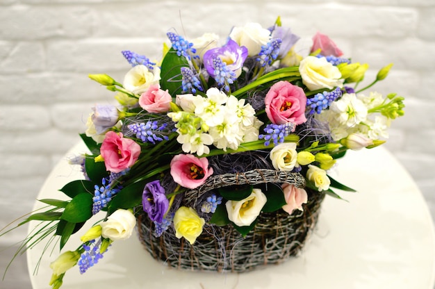 Photo beautiful flower basket on a table. beautiful bouquet of colorful flowers