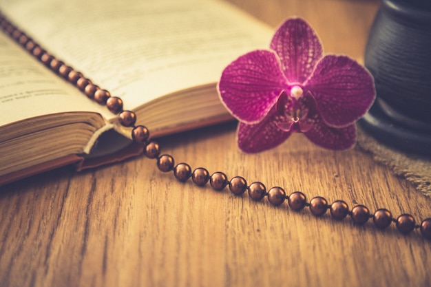 Beautiful flower with old book and cup of coffee or tea. romantic background with retro filter effect