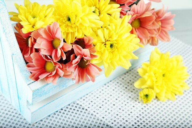 Beautiful flowers in basket on light background