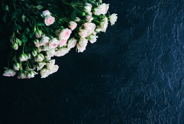 Bellissimi fiori su sfondo nero. mazzo di rose. posa piatta perfetta. cartolina di festa della madre felice. saluto per la giornata internazionale della donna. idea elegante per pubblicità o promozione.