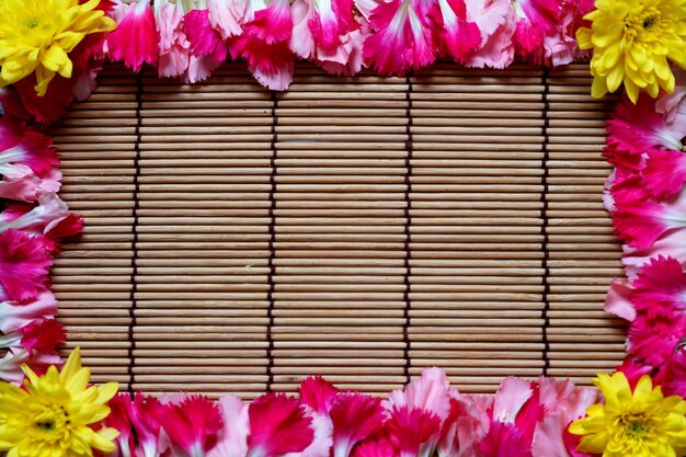 Beautiful flowers frame on bamboo mat background Valentines day