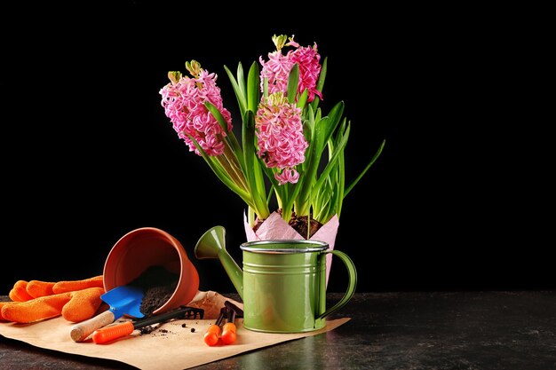 Beautiful flowers and gardener equipment on table