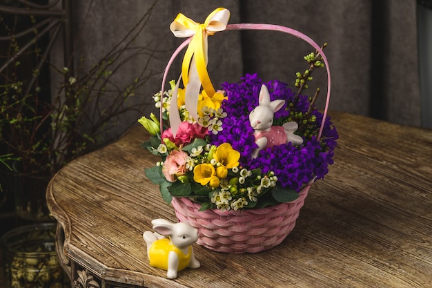 Beautiful flowers and rabbits on a wicker basket