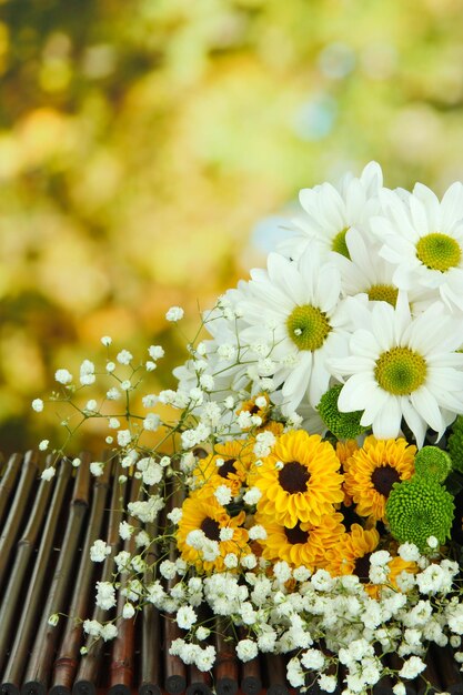 Beautiful flowers on table on bright background