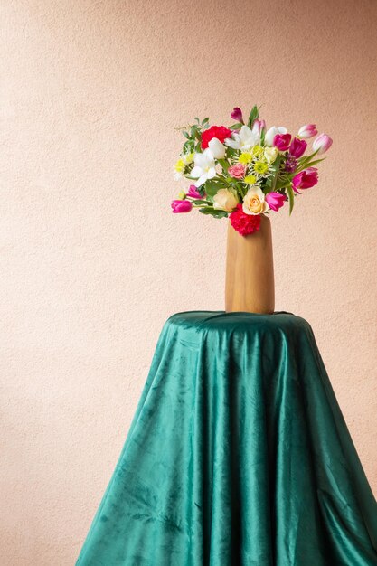 beautiful flowers in vase on table on background wall