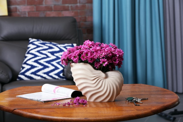 Photo beautiful flowers in vase on table in room