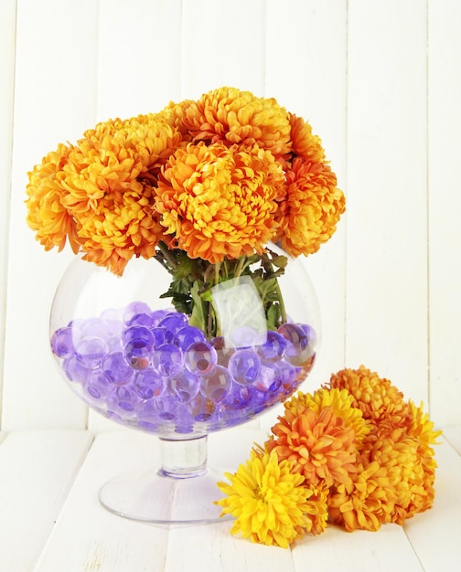 Foto bellissimi fiori in vaso con idrogel sul tavolo su fondo di legno