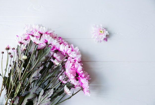 白い背景の上の美しい花。菊の花束。完璧なフラットレイ。幸せな母親の休日のはがき。国際女性デーの挨拶。広告や宣伝のための誕生日のアイデア。