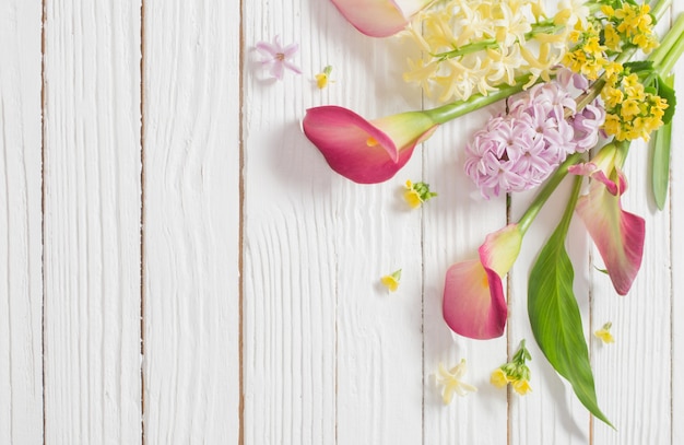 Beautiful flowers on white wooden surface