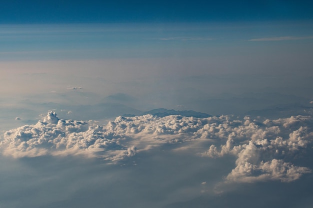 飛行機の窓からのふわふわ雲が美しい