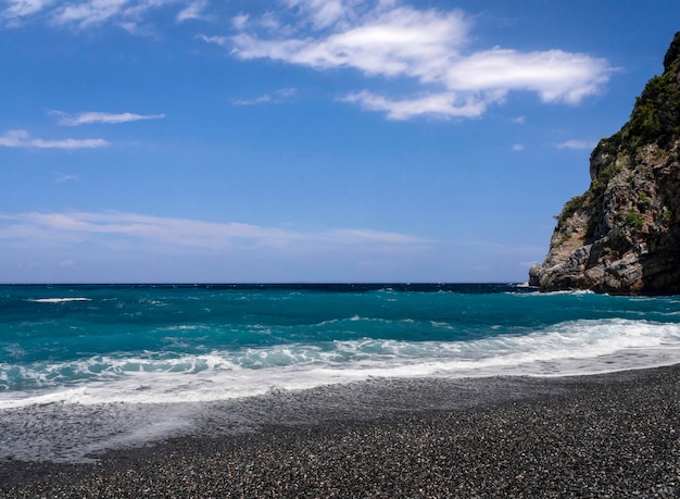 Beautiful foam waves on a sunny day in the Aegean Sea on the island of Evia in Greece