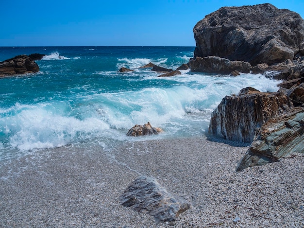 Beautiful foam waves on a sunny day in the Aegean Sea on the island in Greece