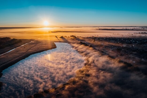 写真 秋の朝,夜明けに湖から美しい霧が畑に出てくる.