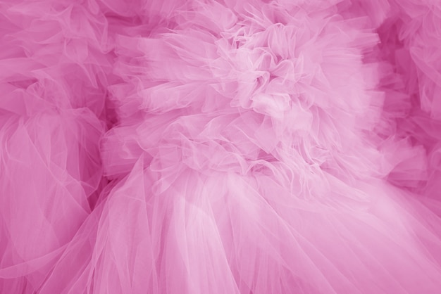 Красивые складки прозрачной ткани розового цвета. текстильная текстура.