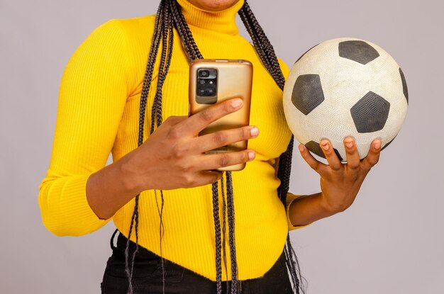 Beautiful football fan holding his phone and checking scores online