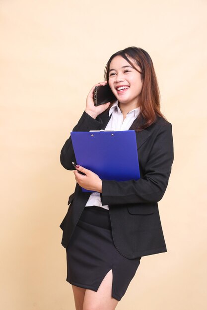 Photo beautiful formal asian executive girl in suit standing happy and pose hugging clipboard and telephon