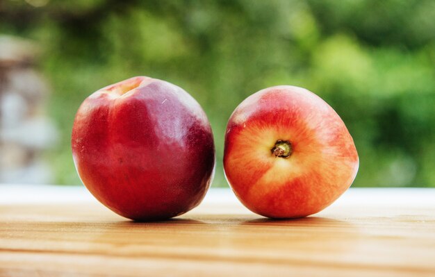 Beautiful fragrant ripe nectarines on the wooden board.