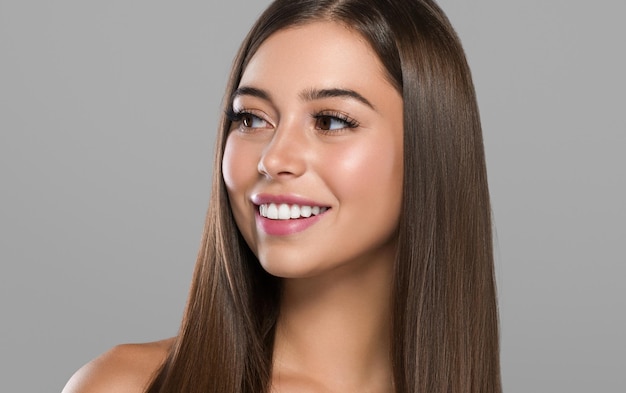 Foto bella donna con le lentiggini capelli sani capelli lunghi e lisci bruna colore di sfondo grigio