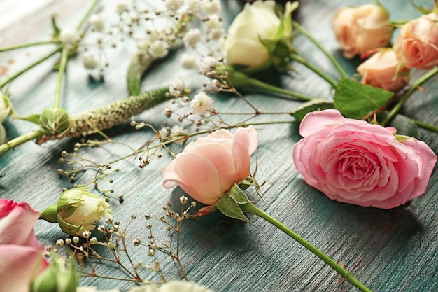 Beautiful fresh flowers on blue wooden background