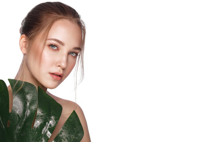 Photo beautiful fresh girl with perfect skin natural makeup and green leaves beauty face photo taken in the studio