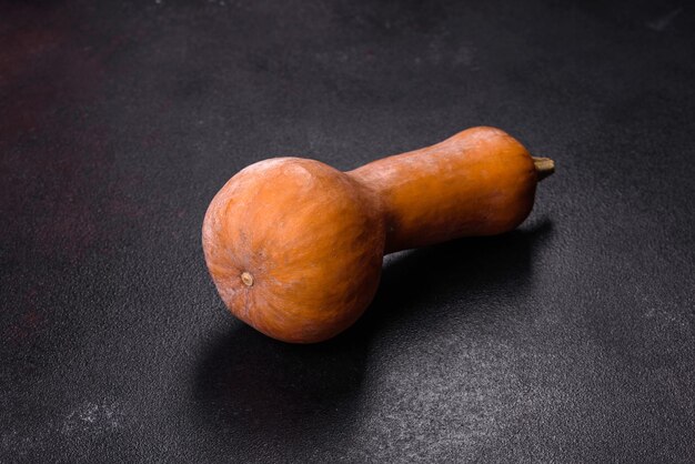 A beautiful fresh orange pumpkin against a dark concrete background