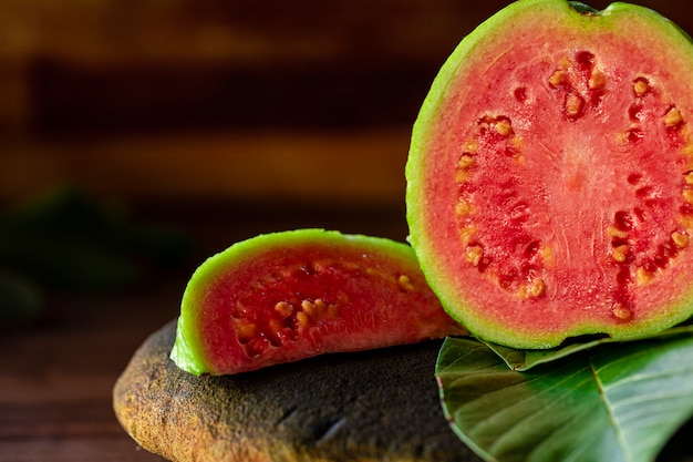 Beautiful fresh red guava, autumn fruit on wooden rustic table