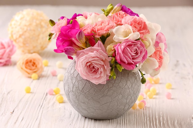 Beautiful fresh spring flowers in pot on wooden table closeup