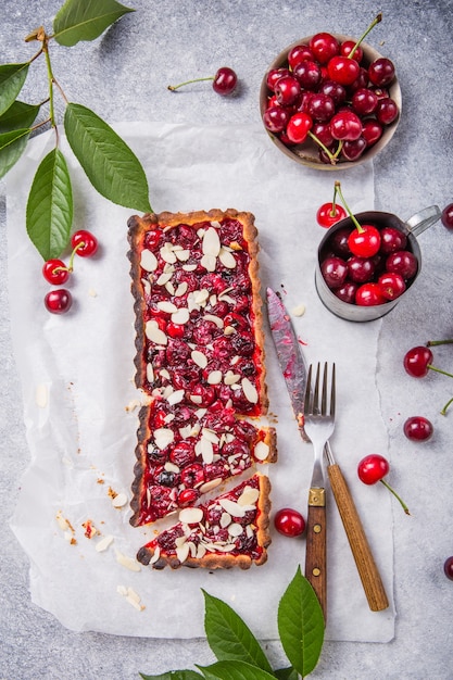 Beautiful freshly made cherry tart decorated with almond chips. Food photography.