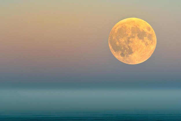 Photo beautiful full moon over the sea at sunrise natural background