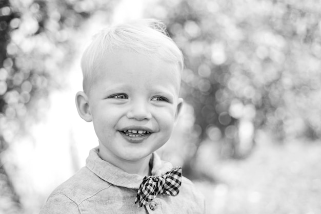 Beautiful fun day for cute little boy in nature Happy child in summer in nature Boy in suit and bowt