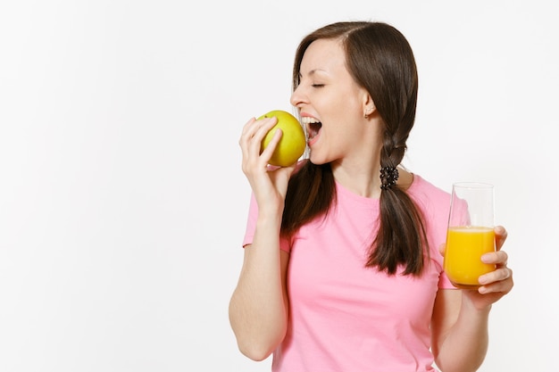 Beautiful fun happy woman holding in hands green apple and orange fresh juice in glass isolated on white background. Proper nutrition, dieting concept. Copy space for advertisement. Advertising area.