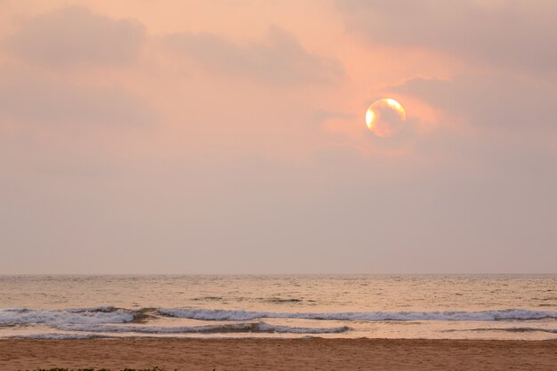 海のそばの美しい優しいピンクの夕日