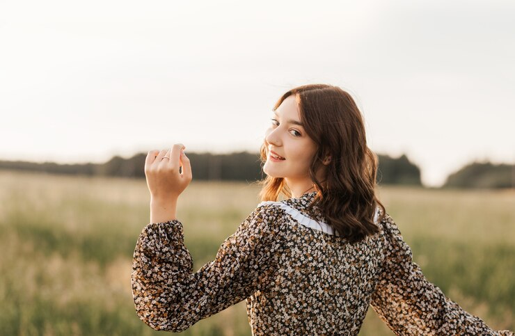 ドレスを着た美しくて優しい10代の少女は、夏に自然の中で歩き、リラックスします