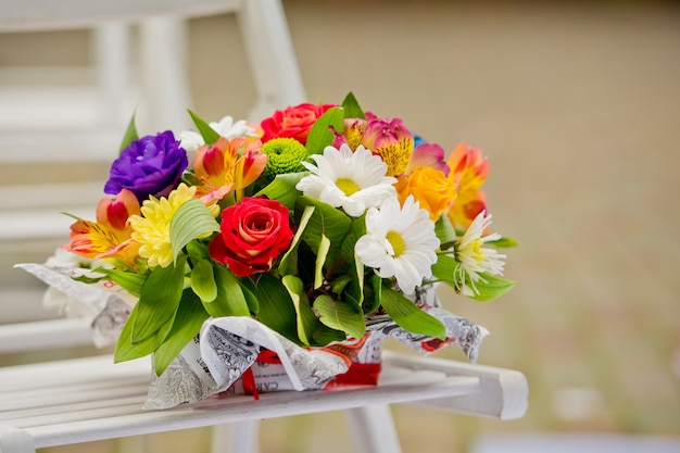 beautiful gift bouquet in a wooden vase on a wooden bench.