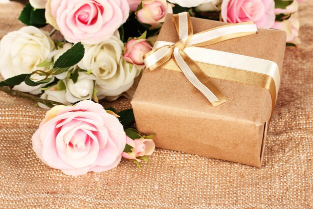 Photo beautiful gift on flowers background