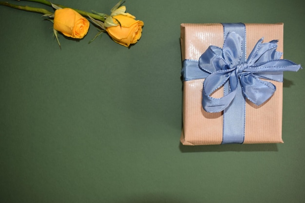 A beautiful gift and two yellow roses on a black background