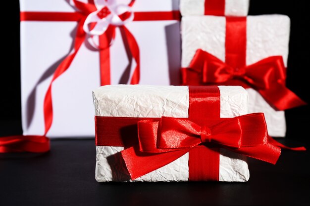 Beautiful gifts with red ribbons, on dark background