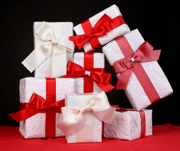 Beautiful gifts with red ribbons on dark background