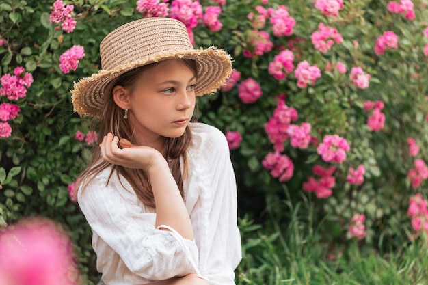 写真 外のピンクのバラの中で美しい少女